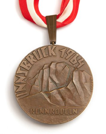 Front: Innsbruck 1964 bronze medal, legend over mountains, luge